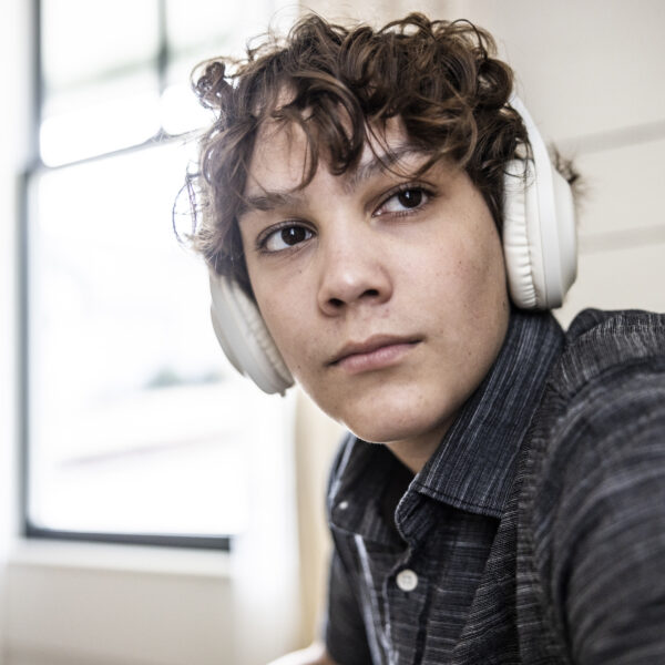 Teenage boy listening to wireless headphones